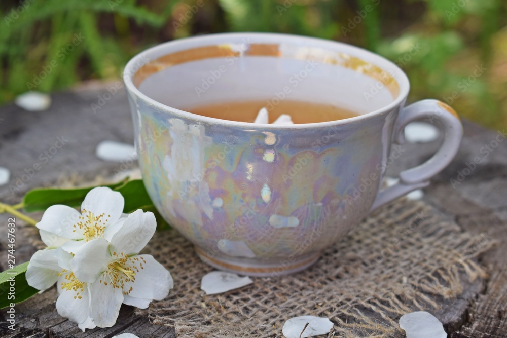 Jasmine flowers and fresh tea on wooden background and burlap. Jasmine flowers and fresh tea on wooden background and burlap.