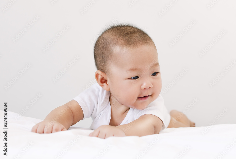 little small asian happy baby infant relaxing and smiling in bed little small asian happy baby infant relaxing and smiling in bed