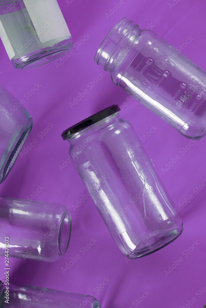 Glass jars with lids, purple background, top view flat lay recycling concept Glass jars with lids, purple background, top view flat lay recycling concept