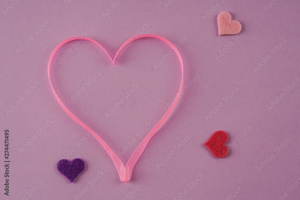 Obraz premium pink ribbon heart on purple background