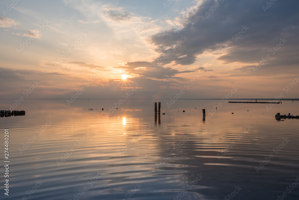 Sunset clouds reflected in the smooth water of the salt lake