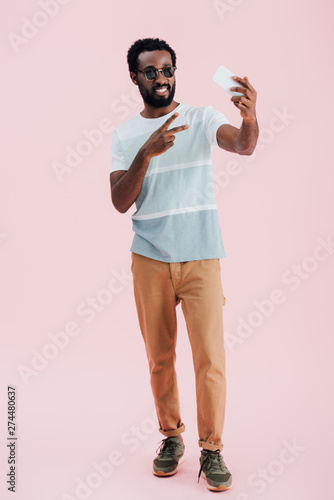 Obraz na plátně african american man in sunglasses with victory sign taking selfie on smartphone