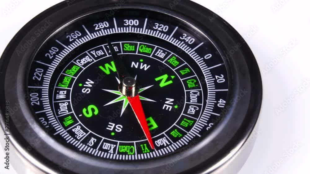 Close up compass rotating on white background. Travel, tourism and exploration Close up compass rotating on white background. Travel, tourism and exploration