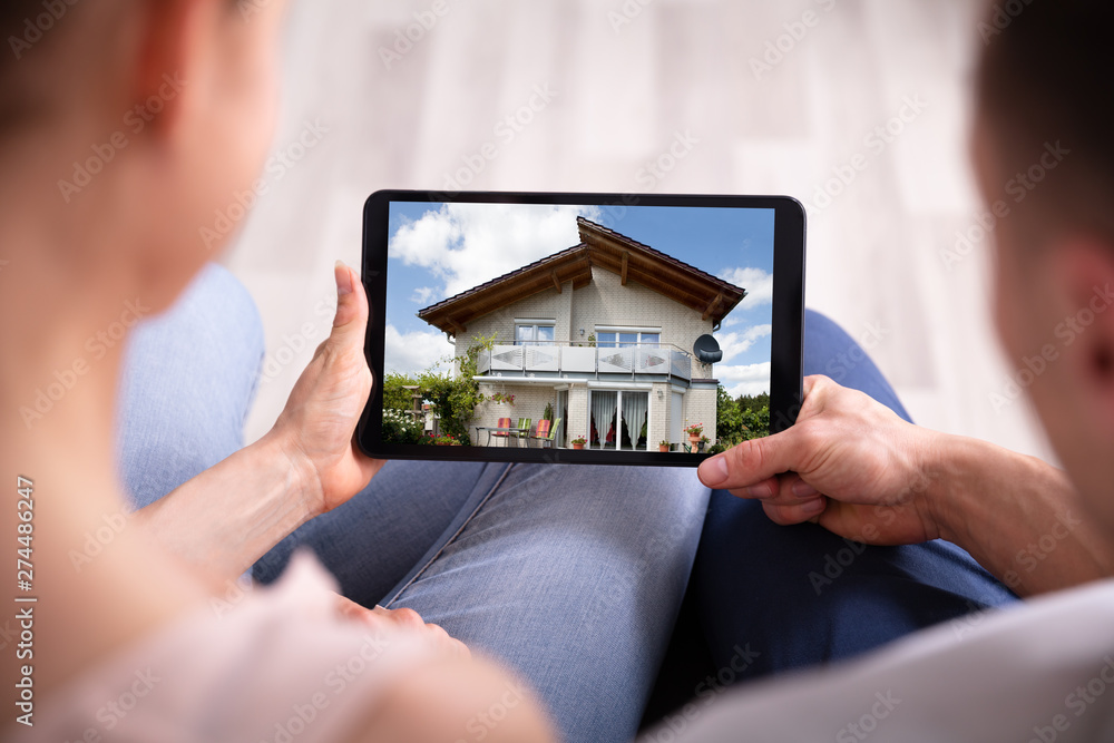 Couple Looking At House On Tablet - obrazy, fototapety, plakaty 