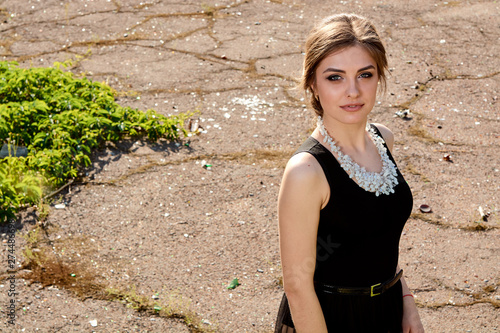 Young attractive woman in the sexy see-through, transparent, transpicuous, diaphanous, clear black dress posing at summer sunny day outdoor in the old park. Fashion woman. Young woman modern portrait. photo