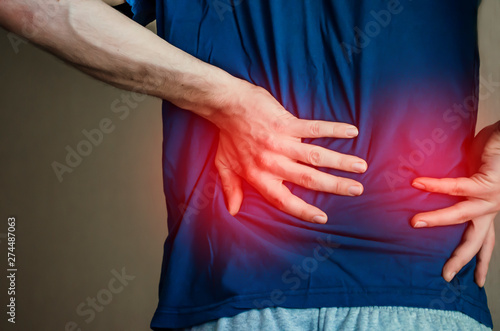 A man holding his back. Back pain.