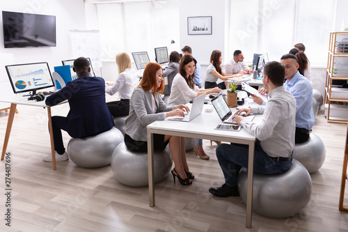 Group Of Businesspeople Discussing While Working In Office