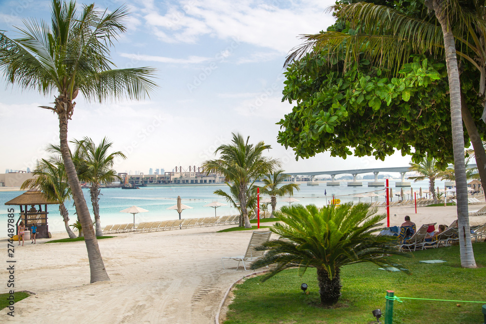 Dubai, UAE, United Arab Emirates. Jumeirah island white sand beach view with palms Dubai, UAE, United Arab Emirates. Jumeirah island white sand beach view with palms
