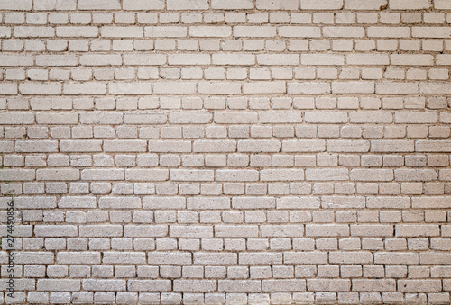 High resolution full frame background of detailed old pale brick wall with vignetting.