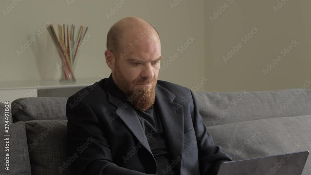 Busy business man working with laptop sitting on couch and exulting.Win,success Busy business man working with laptop sitting on couch and exulting.Win,success
