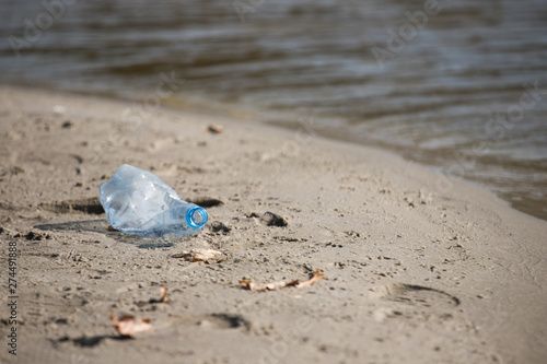 plastic trash bottle on beach. Pollution concept photo