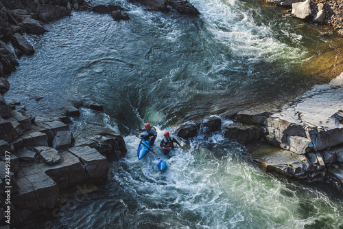 Two man on whitewater catamaran are going through the rapid on the mountain river in early spring © Oleh Bilyk