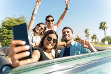 Group of friends riding 4x4 suv and taking a selfie