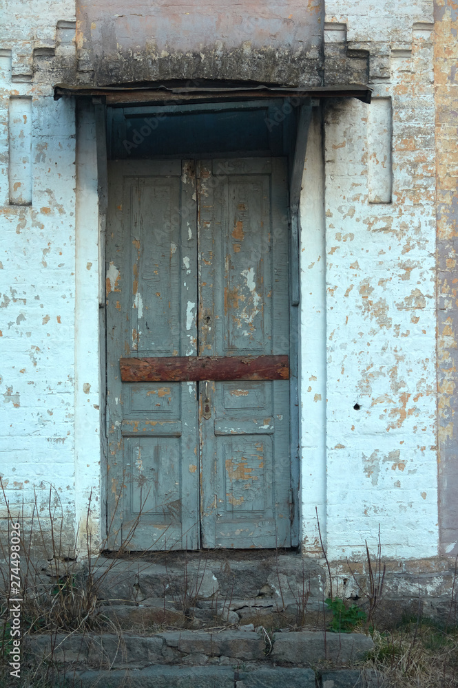 The boarded up door of the facade wall of the nineteenth century building.