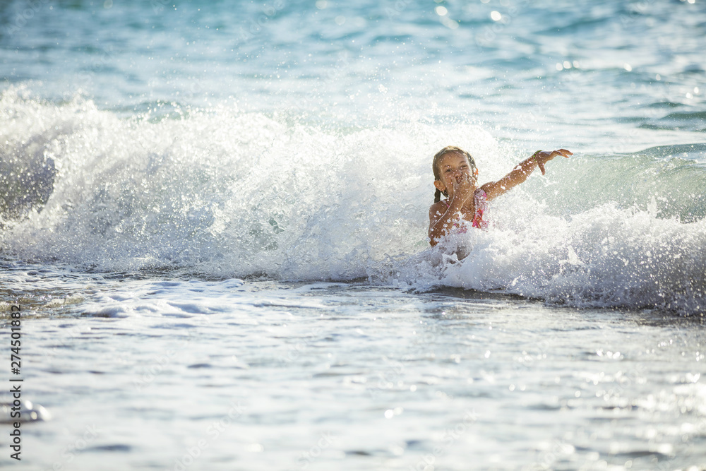 Happy girl playing in breaking waves on beach Happy girl playing in breaking waves on beach