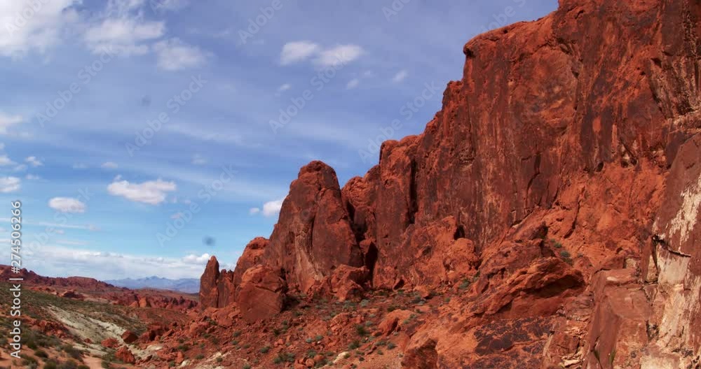 Time lapse of slanted red rock mountain against thin clouds Time lapse of slanted red rock mountain against thin clouds