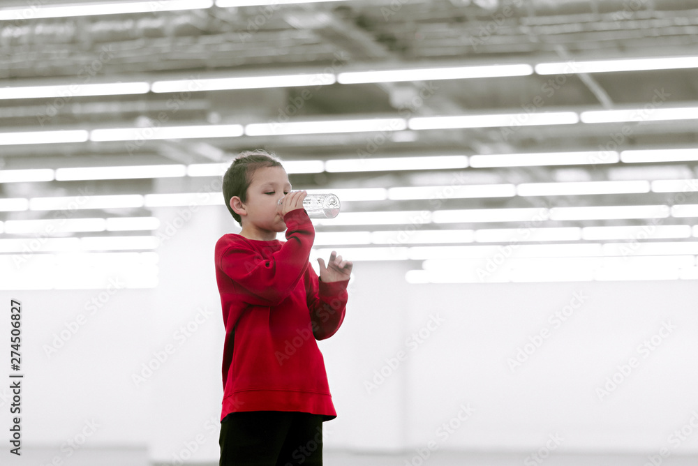 A happy boy is drinking clean water from a glass bottle. White background. Future. A healthy boy is drinking clean water. A happy boy is drinking clean water from a glass bottle. White background. Future. A healthy boy is drinking clean water.
