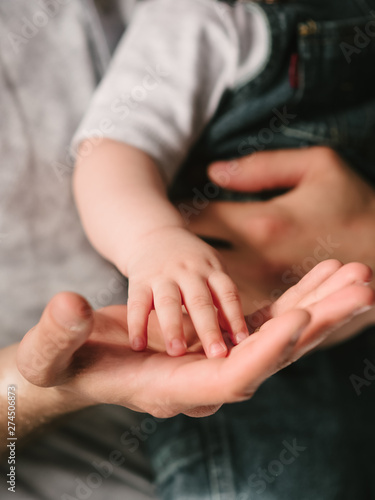 Little palm in the hand of his father. Family and childhood. Son and father.