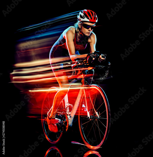 Fototapeta Naklejka Na Ścianę i Meble -  one caucasian woman triathlon triathlete cyclist cycling studio shot isolated on black background with light painting effect