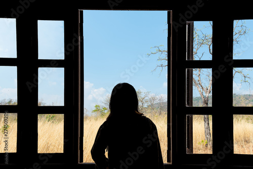 Silhouette woman looking out of window see view nature.concept thniking a freedom. photo