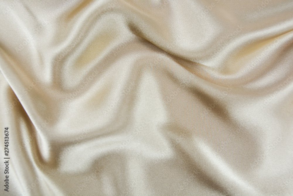 The texture of the satin fabric of beige color for the background The texture of the satin fabric of beige color for the background