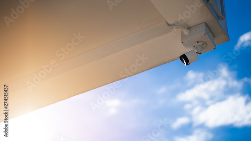 CCTV camera installed in the building with a backdrop of beautiful skies and sunlight.