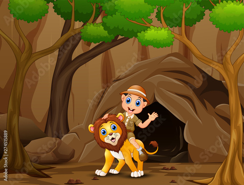 Happy zookeeper boy and lion in front the cave