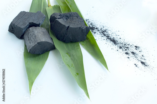 bamboo charcoal with green leaves on white background