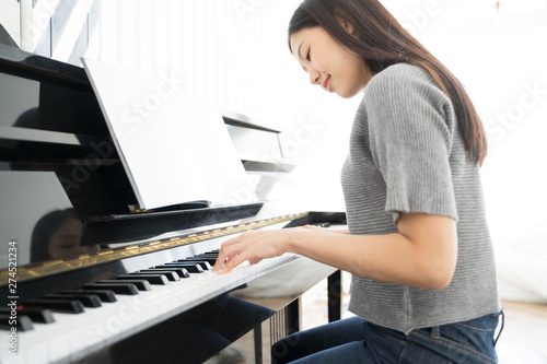 Obraz na plátně Portrait Asian woman playing  playing piano