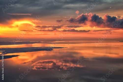 Great Salt Lake Sunset Aerial view from airplane in Wasatch Rocky Mountain Range  sweeping cloudscape and landscape during day time in Spring. In Utah  United States.