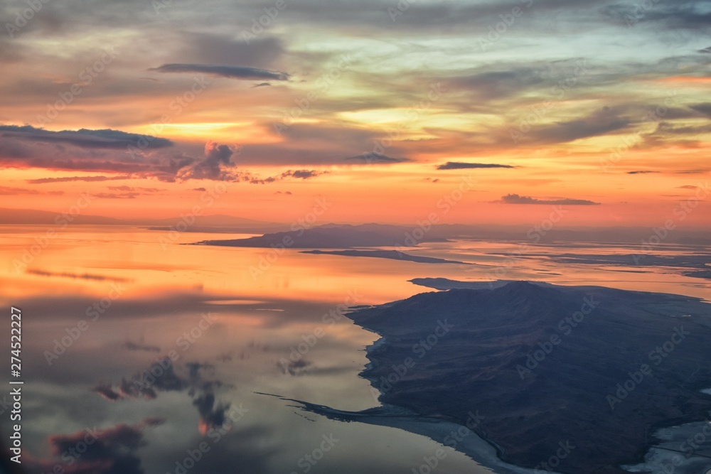 Fototapeta premium Great Salt Lake Sunset Aerial view from airplane in Wasatch Rocky Mountain Range, sweeping cloudscape and landscape during day time in Spring. In Utah, United States.
