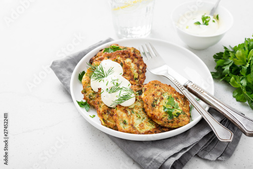Zucchini fritters or pancakes with yogurt dressing with fresh herbs.