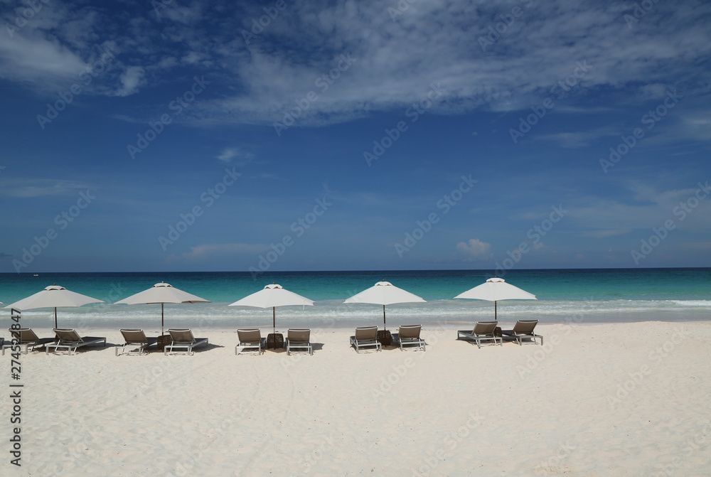 Beach chairs and umbrella on a beautiful Caribbean beach at Harbor Island, Bahamas