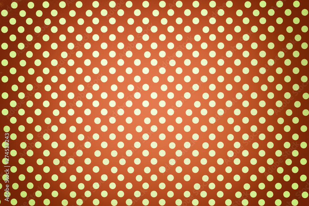 Light orange background from wrapping paper with a pattern of golden polka dot closeup.
