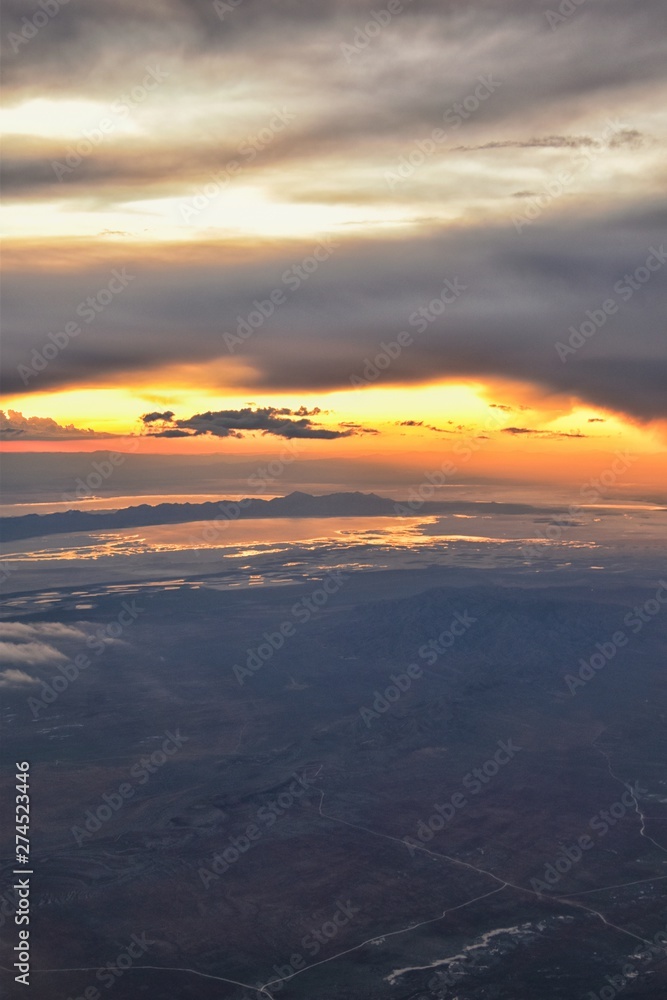 Great Salt Lake Sunset Aerial view from airplane in Wasatch Rocky Mountain Range, sweeping cloudscape and landscape during day time in Spring. In Utah, United States. Great Salt Lake Sunset Aerial view from airplane in Wasatch Rocky Mountain Range, sweeping cloudscape and landscape during day time in Spring. In Utah, United States.