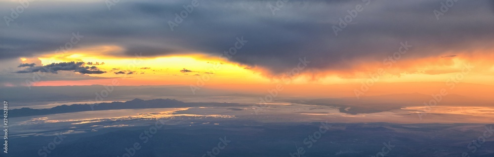 Great Salt Lake Sunset Aerial view from airplane in Wasatch Rocky Mountain Range, sweeping cloudscape and landscape during day time in Spring. In Utah, United States. Great Salt Lake Sunset Aerial view from airplane in Wasatch Rocky Mountain Range, sweeping cloudscape and landscape during day time in Spring. In Utah, United States.