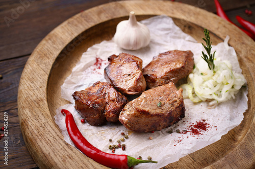 Grilled pork meat with marinated onions garnishing on wooden board. Summer delicious food, weekend bbq party, picnic food