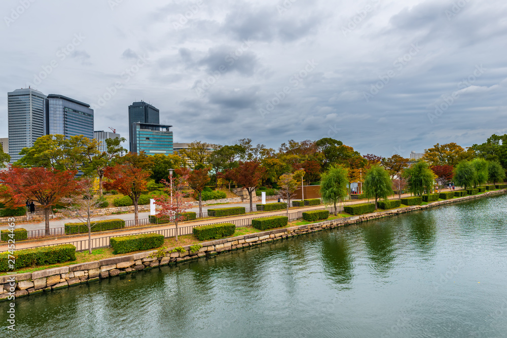 cityscape of autumn scene of Osaka city with park, modern buildings and river, Japan