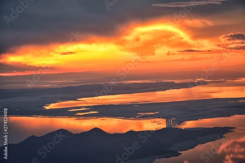 Great Salt Lake Sunset Aerial view from airplane in Wasatch Rocky Mountain Range, sweeping cloudscape and landscape during day time in Spring. In Utah, United States.