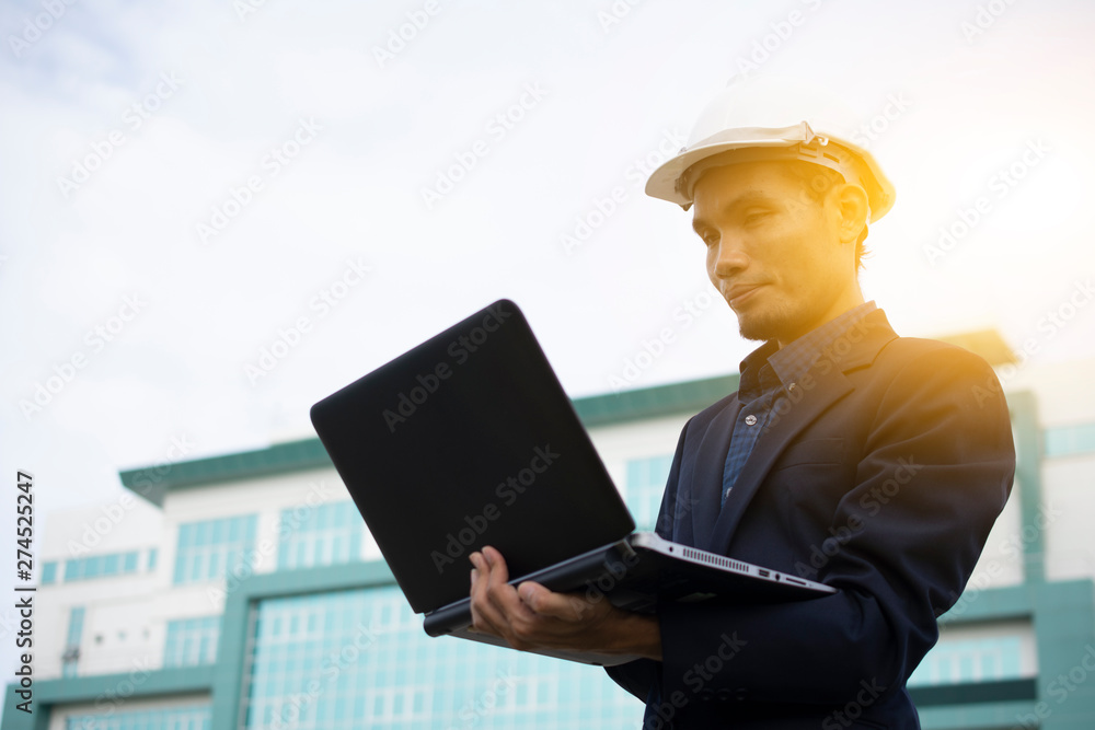 Engineer holding Computer Notebook for work and Sky technology background Engineer holding Computer Notebook for work and Sky technology background
