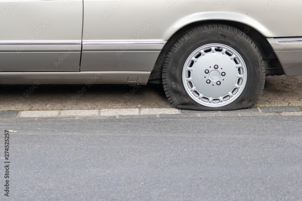 Platter Reifen eines Autos benötigt Hilfe vom Pannendienst oder Abschleppdienst