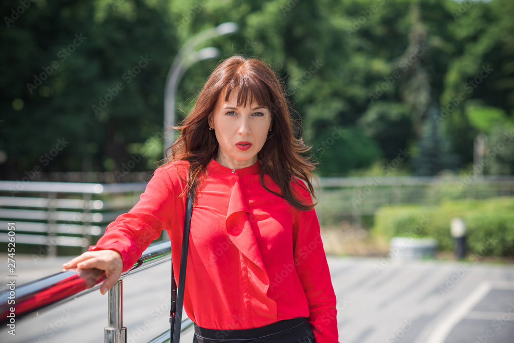 Business woman in city wear red shirt and black skirt, bussinestyle for women Business woman in city wear red shirt and black skirt, bussinestyle for women