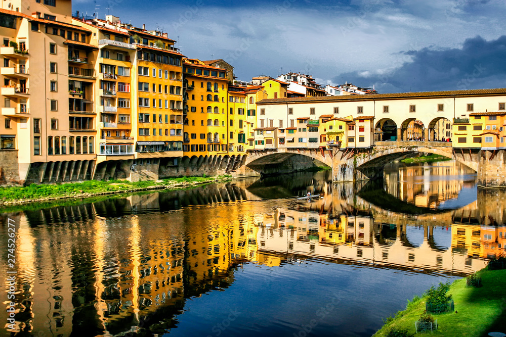 Old bridge Ponte Vecchio with colourful buildings houses and its reflection in the river Arno in Florance, Tuscany, Italy. April 2012