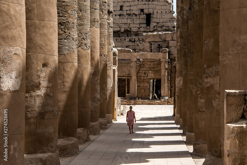 Girl young woman walking beside columns in Egypt Luxor Temple of Ramesses II