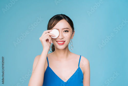 Beautiful woman with cotton pad, smiling