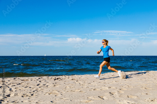 Young woman running, jumping on beach © Jacek Chabraszewski