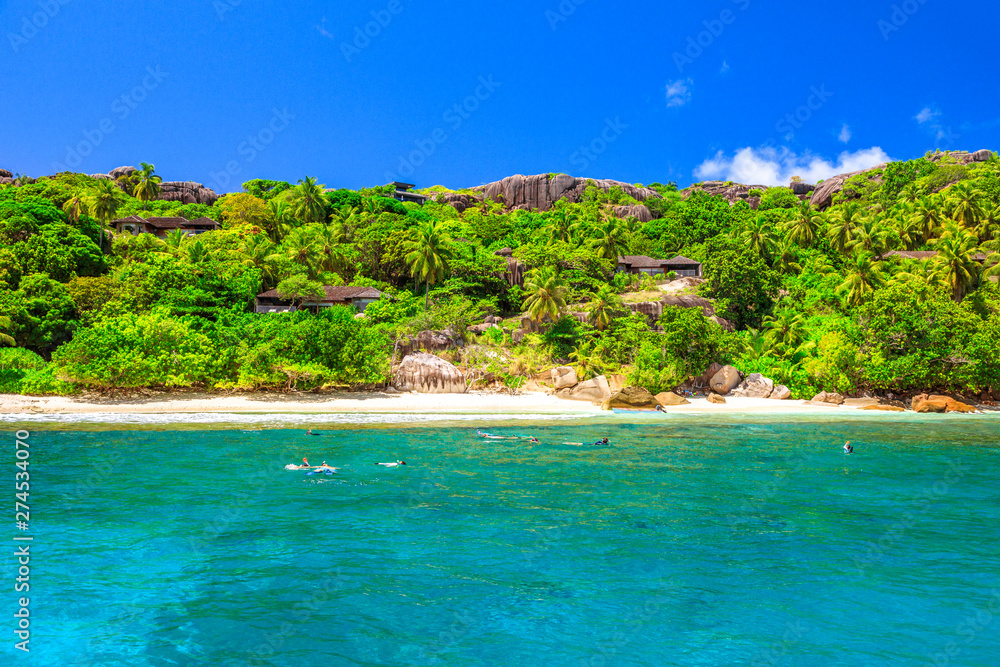 Felicite island at Seychelles seascape in Indian Ocean. People snorkel at Ramos National Park. Granite bloulder stones and turquoise bay. Snorkeling paradise in Marine Park. Tropical nature background