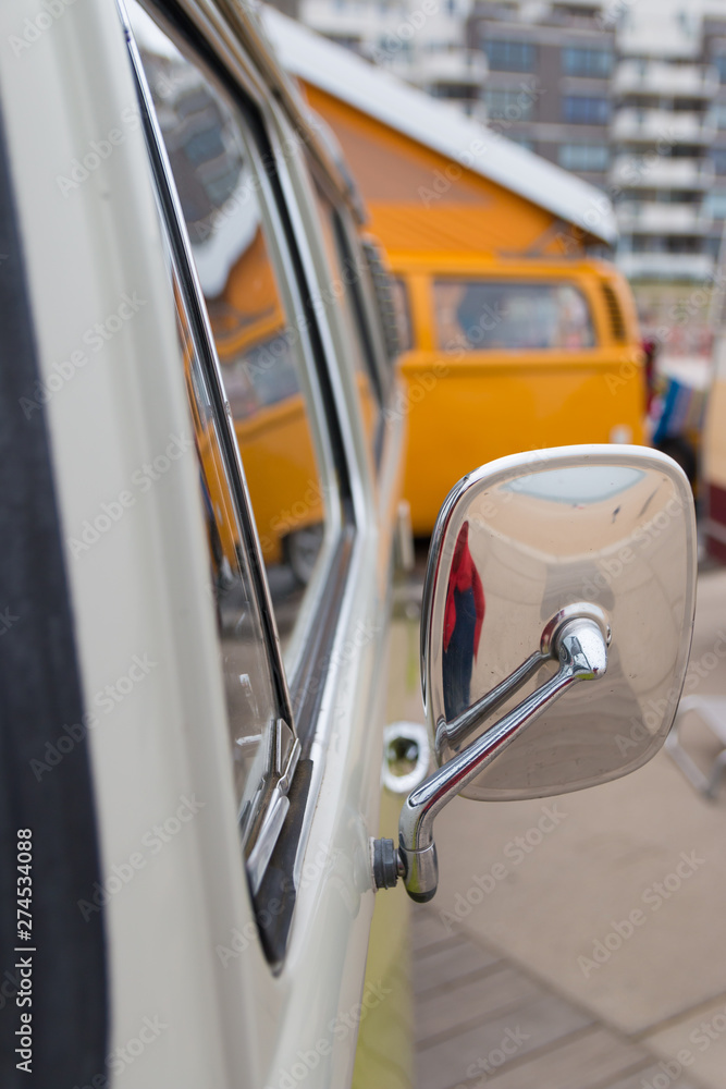 closeup view chrome mirror and blurred background of 1960s style combi in vertical portrait view closeup view chrome mirror and blurred background of 1960s style combi in vertical portrait view