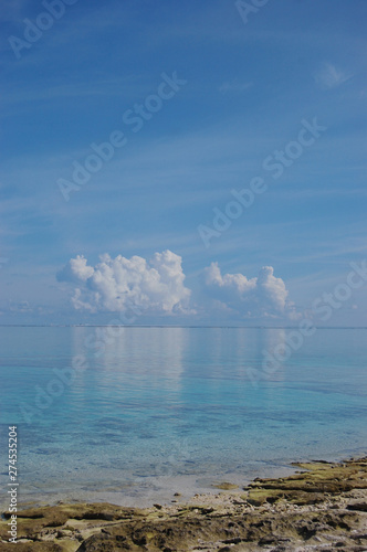 南国沖縄のエメラルドグリーンの海に反射する積乱雲