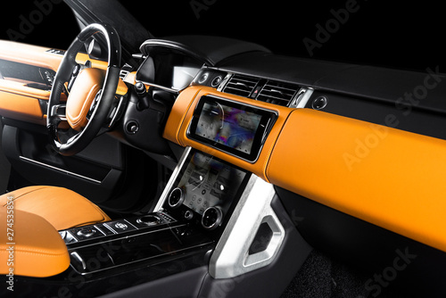 Orange red sand leather luxury car inside Interior - steering wheel, shift lever and dashboard.